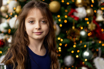 Portrait of girl in illuminated christmas tree