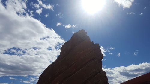 Low angle view of rocks against sky on sunny day