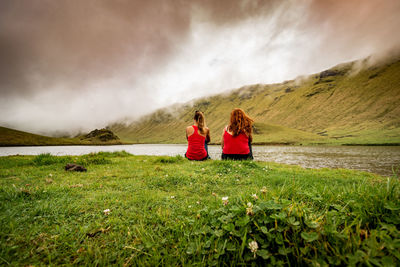 Two friends sitting in nature, landscape, caldera of corvo, azores.