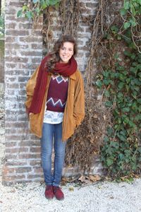 Portrait of smiling young woman leaning against brick wall