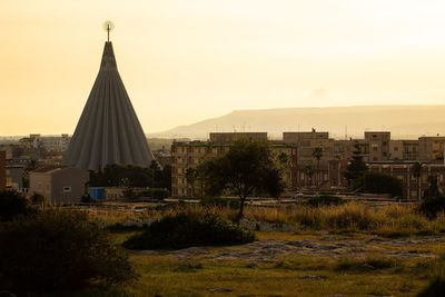 Buildings in city against sky during sunset