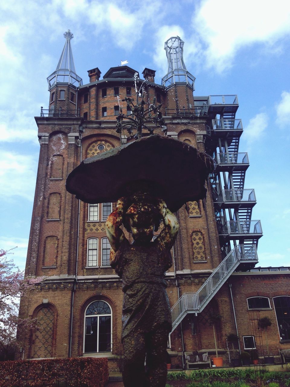 architecture, building exterior, built structure, low angle view, sky, human representation, statue, sculpture, art and craft, cloud - sky, art, creativity, history, religion, cloud, cloudy, outdoors, day, travel destinations