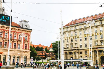 People on street by buildings in city