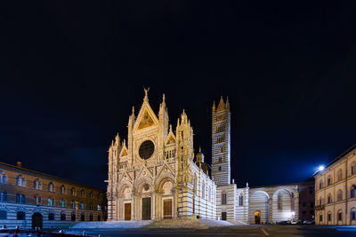 Low angle view of illuminated building against sky at night