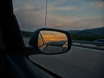 Reflection of car on road at sunset