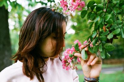 Close-up of girl with pink flowers on tree