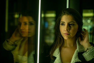 Young woman looking through glass window