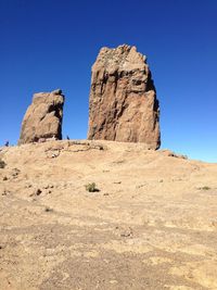 Rock formations in desert against clear blue sky