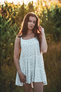 Young woman standing against plants