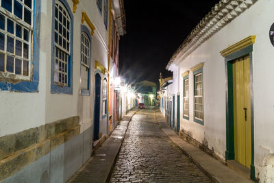 Empty street amidst buildings at night