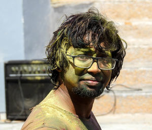 Portrait of bearded young man with powder paint during holi