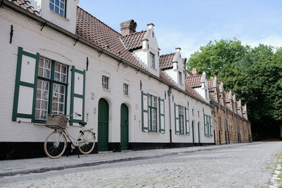 Bicycle by building against sky