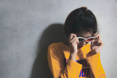 Portrait of woman standing against wall