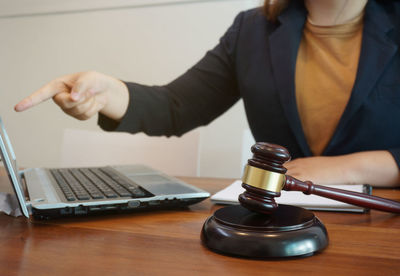 Midsection of man using laptop on table