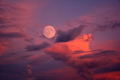 Full moon in sky with pink clouds
