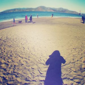 Shadow of woman on beach against sky