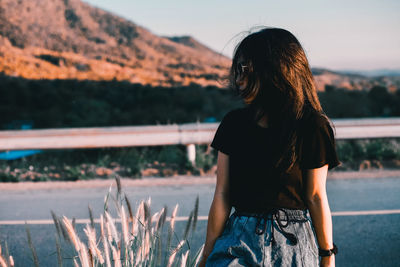 Rear view of woman standing against sky