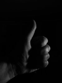 Close-up of human hand over black background