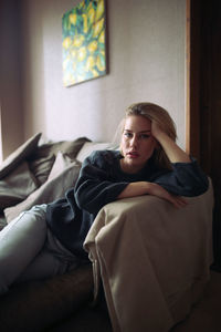 Young woman sitting on sofa at home