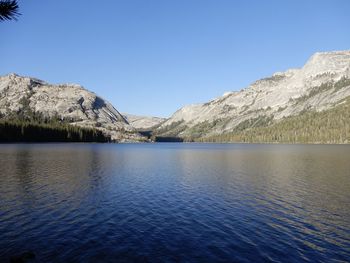 Scenic view of lake and mountains against clear blue sky