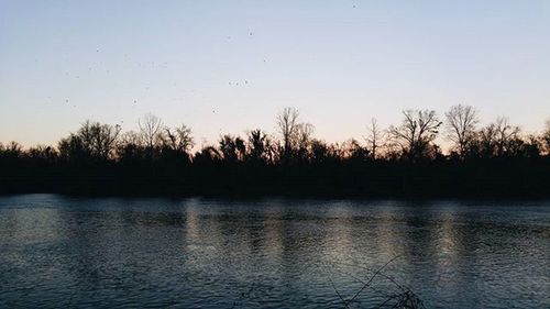 Scenic view of lake against sky at sunset