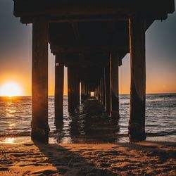 Pier over sea against sky during sunset