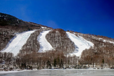 Many ski slopes in winter with frozen lake at bottom