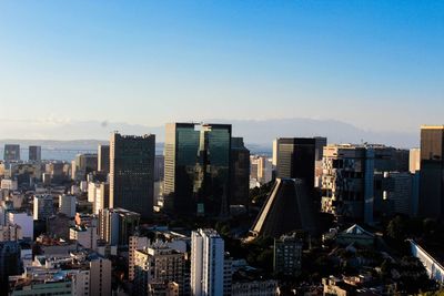 Aerial view of buildings in city against clear sky