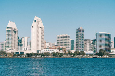 Buildings by sea against sky