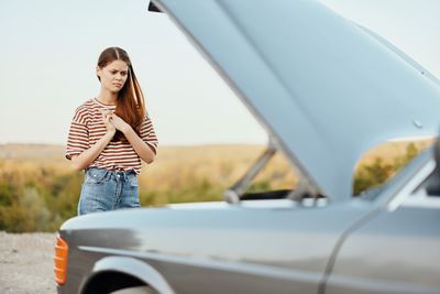 Side view of young woman sitting in car