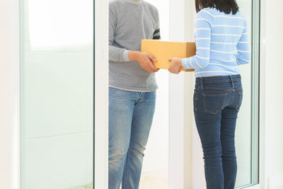 People standing by window at home