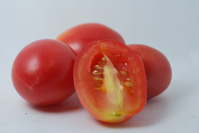 Close-up of tomatoes on table against white background