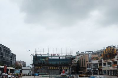 Buildings in city against cloudy sky