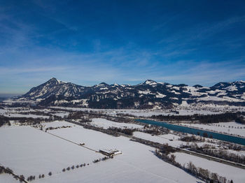 Scenic view of snowcapped mountains against blue sky