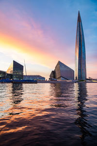 View of sailboat in city at sunset