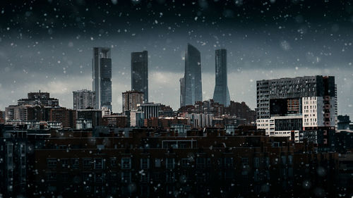 Buildings in city against sky at night