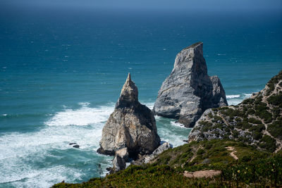 Panoramic view of rocks on sea shore against sky