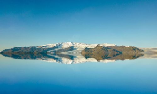 Beautiful scenery of mountains in iceland with blue sky and water reflection. 