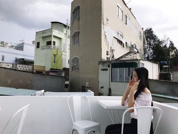 Woman sitting in front of building