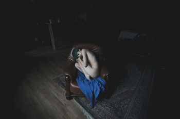 YOUNG WOMAN SITTING AT HOME