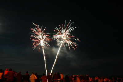 Low angle view of firework display against sky at night