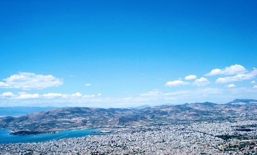 Townscape and mountains against blue sky