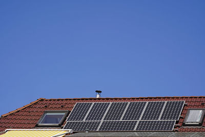 Solar modules on a tiled roof between skylights. 