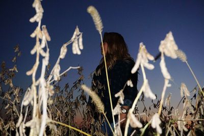 Rear view of woman on field against clear sky