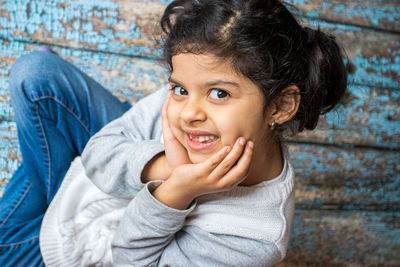 Portrait of smiling girl sitting on wooden floor