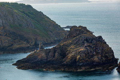 Scenic view of rock formation by sea against sky