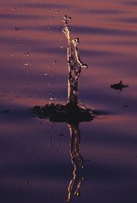 Close-up of water splashing in lake against sky during sunset