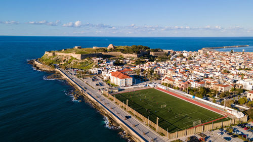 High angle view of buildings by sea against sky