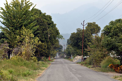 Road amidst trees against sky