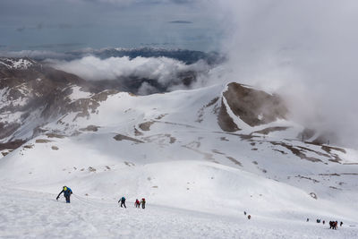 Aerial view of people skiing on snowcapped mountain